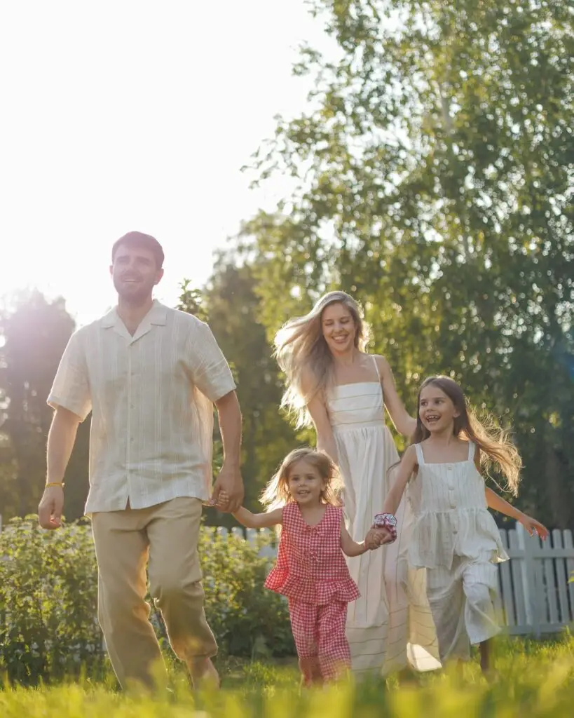 A happy family walking hand in hand through a sunlit garden